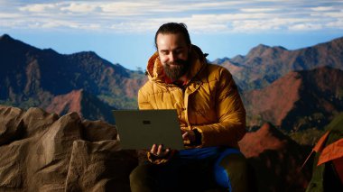 Doğayı seven işkolik her zaman internete bağlanır ve dizüstü bilgisayarda kayar, nefes kesici manzaralı dağın tepesinde güçlü bir sinyalin tadını çıkarır. Kesintisiz çalışma. Kamera B.