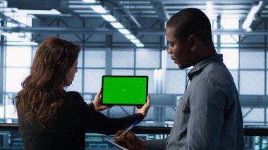 Sunucu çiftliğindeki sistem yöneticileri ayarları doğrulamak için izole ekran modelleme tableti kullanıyorlar. Veri merkezi meslektaşları yeşil ekran kroma anahtar aygıtı kullanarak tesisi, kamera A 'yı izliyorlar.