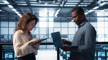 Veri merkezinde bilgisayar ve tablet kullanan geliştiriciler, güvenlik yamalarını çalıştıran, güvenlik duvarını koruyan. Sunucu tarım işçileri güvenlik taraması yapmak için aygıtlar kullanıyor, veri koruması sağlanıyor, kamera B