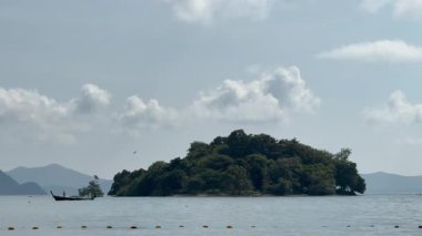 Tayland, Kasım 2024 - İnsanların eğlence için kano ya da yelkenli kullandıkları tropikal kıyı şeridi, kumlu sahil ve palmiye ağaçları huzurlu bir manzara yaratıyor. Egzotik sakin kıyı şeridi.