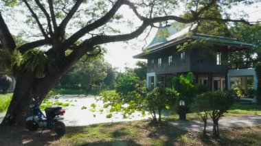 Göl kenarındaki ahşap tropikal bina fil barınağında nilüfer çiçekleri, koruma merkezi büyük memeliler için koruma alanı sunuyor, vahşi yaşam parkı..