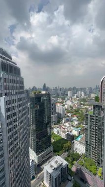 Şehir merkezinin ortasında büyük pencereleri olan dikey video Tayland gökdelenleri. Şehir merkezi, nefes kesici mühendislik ve altyapısı olan şirket alanı. Şehir manzarası metropolü.