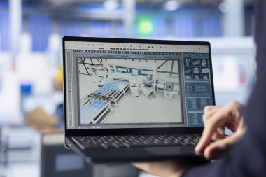 Güneş panelleri, dizüstü bilgisayar kullanarak yeni fotovoltaik materyaller ve teknolojiler geliştiren fabrika işçisi üretiyor. Fotovoltaik fabrikasını kapatın. Defter üzerinde deneyler yapan bir uzman.