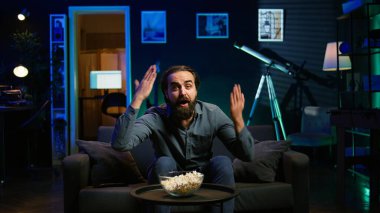 Destekçi canlı yayında spor maçı izliyor. Öfkeli bir takımın hatası yüzünden kanepede kuduruyor. Kızgın adam futbol müsabakalarına bakıyor bastırılmış duygularını açığa vuruyor, kamera B