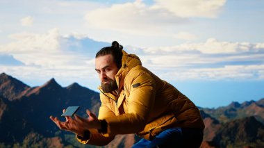 Aptal yürüyüşçü dikkatsiz davranıp akıllı telefonu düşürüyor ve dengesini kaybediyor. Dağlık alana uygun donanımsız biri. Doğada teknolojik bir saplantıyla yürüyüş yapma riski. Kamera B.