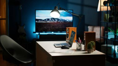 Çağdaş bir ofis düzeneği olan rahat bir apartman dairesi. Ahşap mobilyalar, televizyon ve ev bitkileri modern iç tasarımı, konfor ve yaratıcılığı ön plana çıkarıyor..