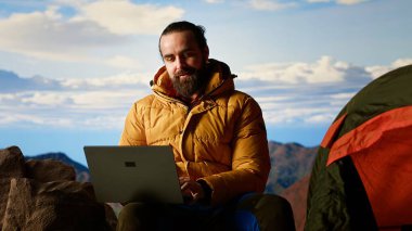 İşkolik kâşif her zaman kesintisiz işlere bağlanır ve bağımlıdır. Dağın tepesinde dizüstü bilgisayarını açar. İnternet bağımlısı genç yürüyüşçü güçlü sinyallerden hoşlanıyor. Kamera B.