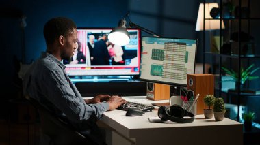 Ev ortamından faaliyet gösteren erkek serbest çalışan, parasal verileri değerlendiriyor ve işi genişletmek için uluslararası sermaye kaynaklarını araştırıyor. Mali analist bütçe dengesini onayladı. Kamera A.