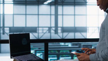 Bilgisayar ve tablet entegre yapay zeka otomasyon araçlarıyla veri merkezinde teknisyen. Sunucu odası çalışanı, aygıtlar üzerinde yapay zeka kullanarak, sürekli boş zamanı garantiliyor, kamera A