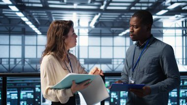 Veri merkezinde toplanan neşeli yöneticiler raporları ve dosyaları inceleyip tokalaşıyorlar. Sunucu odası çalışanı iş arkadaşını selamlıyor, arayı kapatmak için sorun vuruşu yapıyor, kamera B