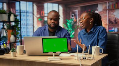 Afrika kökenli Amerikalı çiftler krom anahtarın yanındaki sorun çözme rehberine göz atıyorlar. Yönlendirici sorunlarını çözmek ve ev ağlarını onarmak için birlikte çalışıyorlar. Bağımsızlar kızıyor. Kamera A.