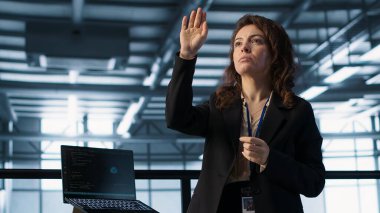 Yüksek teknoloji yapay zeka veri merkezindeki teknisyenler hologram görselleştirmesine bakıyor. AR yapay zeka teknolojisi ve kamera A kullanarak sunucu odası donanımı sağlama almaya çalışan programcı.