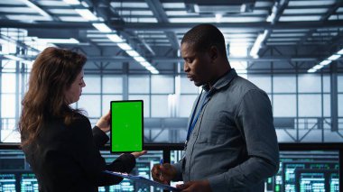 Veri merkezinde yeşil ekran tableti kullanan mühendisler altyapının güvenilirliğini kontrol ediyor, panoya yazı yazıyorlar. Sunucu odasında modelleme aygıtı kullanan işçiler, sunucu viralizasyonunu yönetenler, kamera B