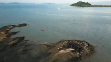 Tropikal manzarası ve gizli cenneti olan tenha bir sahil manzarası, el değmemiş kumlu plajlar, palmiye ağaçları ve çarpıcı okyanus sularındaki küçük adalar. Egzotik manzara.