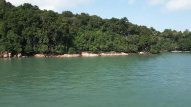 Tayland kıyılarındaki yemyeşil bir ada gibi, mavi okyanus, beyaz kumsal ve palmiye ağaçlarının muhteşem insansız hava aracı görüntüleri. Rüya gibi bir tatil için güzel kıyı şeridi ve lüks tatil beldeleri.