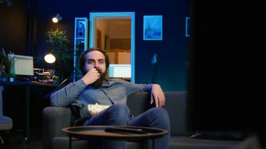 Neşeli ev sahipleri TV 'yi komedi filmleri izlemek için kullanıyor, komik şakalara gülüyorlar. Ev sinemasında ışıl ışıl eğlenen, mizahi film sahnesiyle eğlenen, kamera B