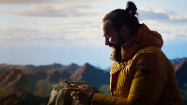 Trekker, yüksek rakımlı hava ve nefes kesen manzaranın farkındalığı teşvik ettiği dağlarda sakin bir anın tadını çıkarıyor. Rahatlama ve kendini geliştirme. Kamera B.