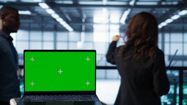 Veri merkezinde yürüyen yazılım geliştiricilerinin önündeki model dizüstü bilgisayar, ekipman teşhislerini gözden geçiriyor. Sunucu çiftliğindeki takım çalışması yapan bilişim uzmanlarının yanındaki izole ekran defterini kapat