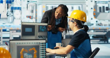 Fotovoltaik fabrika mühendisi CAD programında tesis ayarlaması yapıyor, kadını gösteriyor. Güneş panelleri montaj hatları dizayn eden teknisyen, Afrikalı Amerikalı yönetici, kamera B