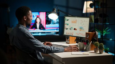 Ağ analisti bilgisayardaki dijital ticaret ilerleme raporlarını inceliyor, kazancı artırmak ve hissedar desteği kazanmak için evde çalışıyor. Uzman şirket bilgilerini analiz eder. Kamera A.