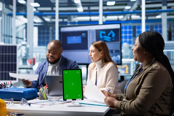 Fotovoltaik fabrikası teknisyenleri güneş panelleri verimliliğini arttırmak için izole ekran tableti kullanıyorlar. Güneş panelleri, sürdürülebilir güneş çözümlerini model kullanarak araştıran fabrika iş arkadaşları üretiyor.