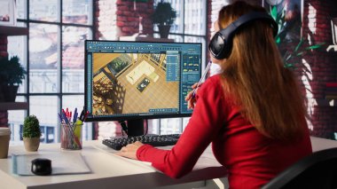 Kadın çalışan, binanın içini mimari yazılım ve planlarla 3D olarak tasarlıyor. Döşemeyi kişiselleştirmek için bilgisayar destekli araçlar ve modeller kullanır. Kamera B.