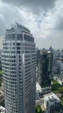 Bangkok 'un ortasında büyük pencereleri olan şehir merkezinin üzerinde nefes kesici mühendislik ve altyapısı olan dikey video gökdelenler yükseliyor. Şehir manzarası