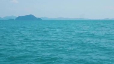 Muhteşem turkuvaz okyanus suları ve dalgalarıyla çarpıcı bir sahil. Güzel bir kıyı şeridi manzarası ve dalgaları olan küçük bir Tayland adası. Tropik cennet deneyimi ve manzarası.