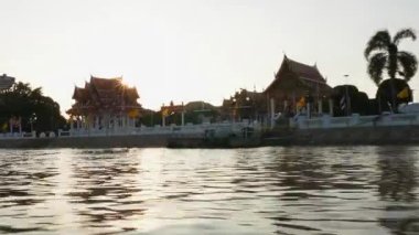 Tayland, Kasım 2024 - Tayland 'da tropik bir cennette tekne gezisi, yemyeşil ve geleneksel evlerle çevrili huzurlu nehirde süzülen bir tekne manzaralı macera.