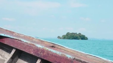 Geleneksel tekne, kıyı şeridi boyunca gizli bir Tayland cennetine doğru yelken açıyor. Köy teknesi ıssız bir adanın yakınında yelken açıyor. Turkuaz sular ve tropikal bir kıyı şeridi onu cennet gibi bir yolculuk yeri yapıyor..