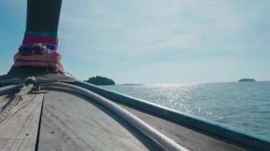Tahta yelkenli, Tayland kıyı şeridi boyunca turkuaz sularda yüzüyor. Okyanusun ortasındaki küçük vahşi adaları gösteriyor. Turistler tropikal gölde yelken açmak için tekne kullanıyorlar..