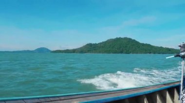 Tayland teknesi tropikal kıyı şeridi boyunca yüzen egzotik bir adanın yanında kristal berrak sularda süzülüyor ve egzotik manzaraların güzelliğini gösteriyor. Tayland 'da cennet tatili.