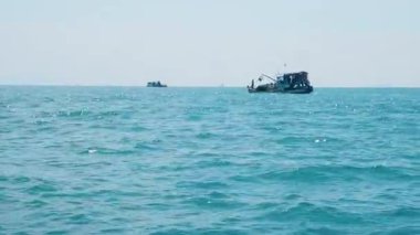Geleneksel tekne, kıyı şeridi boyunca gizli bir Tayland cennetine doğru yelken açıyor. Köy teknesi ıssız bir adanın yakınında yelken açıyor. Turkuaz sular ve tropikal bir kıyı şeridi onu cennet gibi bir yolculuk yeri yapıyor..