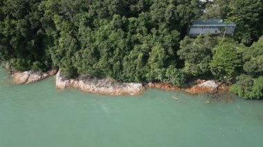 Bir ada kıyısındaki egzotik yağmur ormanlarının insansız hava aracı görüntüleri, yoğun palmiye ağaçları ve tropikal yeşillikler. Mavi okyanus suları olan güzel Tayland manzarası, tatil için mükemmel..