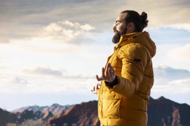 Stres atmak için meditasyon yapan memnuniyet yürüyüşçüsü dağın tepesinde rahatlık ve denge sağlamak için dinleniyor. Genç gezgin, dikkat çekmek için meditasyon yapıyor..
