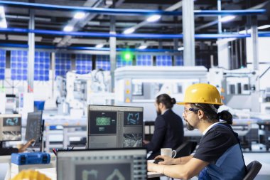 PC, maksimum verimlilik için ince ayar sistemi kullanarak güneş enerjisi üretim makinelerini programlayan fotovoltaik fabrikası çalışanı. Güneş paneli montaj işi yapan teknisyen