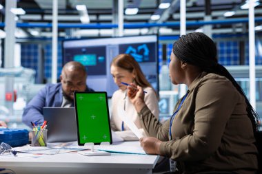 Hissedarlar, anlaşma fizibilitesini değerlendirmek amacıyla geri dönüşleri tasarlamak için model aygıt kullanıyorlar. Münferit ekran tableti kullanan muhasebeci, ilgili yatırımcılar için mali analiz yapıyor