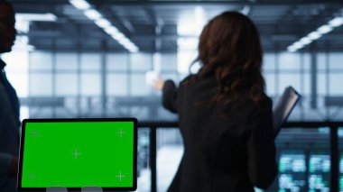 Veri merkezi teknisyenlerinin önünde ölçümleri analiz eden kroma anahtarına odaklan. İzole edilmiş ekran tabletini, sorunsuz işlemleri sağlayan sunucu merkezi işçilerinin yanına kapat, kamera B