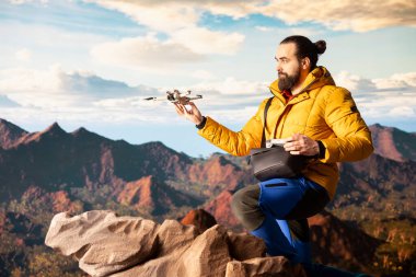 Seyahat meraklısı, insansız hava aracı görüntüleriyle onun faaliyetlerini yakalıyor. Manzaralı dağ aralığı vadisini belgeliyor. Uzaktan kumandalı güzel hava görüntüleme vlog 'u çekiliyor.