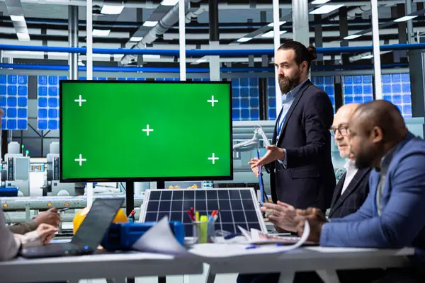 Müdür, kroma anahtar monitörü kullanarak yatırımcılara güneş panelleri materyalleri sunuyor, fon sağlıyor. İşadamı, izole ekran ekranı kullanılarak perdede sanayi tesisi varlıklarını hissedarlara gösteriyor