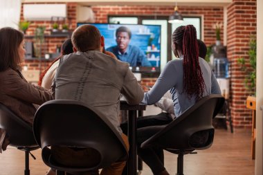 Dijital ekranda görülen erkek işverenle yapılan sanal toplantı sırasında iş yerinde oturan meslektaşların dikiz aynası. Siyahi işadamlarının iş arkadaşlarıyla konuştuğu video ekranı.