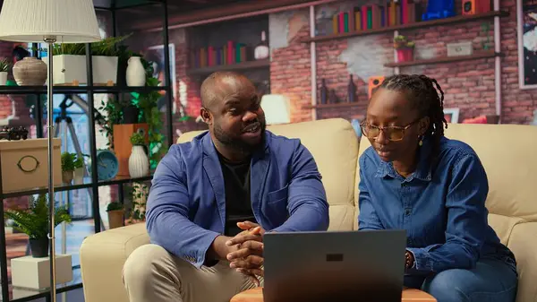 Siyah adam ve kadın rahat dairelerinde oturup dizüstü bilgisayarda dijital pazarlama stratejilerini tartışıyorlar. Birbirlerine uzak işlerinde ve serbest yolculuklarında destek oluyorlar. Kamera A.