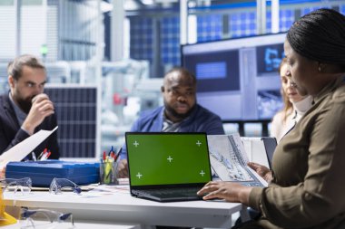 Fabrika yönetimi şemaları gözden geçirir, izole ekran dizüstü bilgisayar kullanarak çalışmayı planlar. Güneş panelleri fabrika hissedarları montaj hatlarına, şemalara, model defterlere bakarlar.