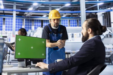 Photovoltaics fabrika müdürü işçilere üretim akışını nasıl optimize edeceğini göstermek için yeşil ekran PC kullanıyor. Sürdürülebilir enerji güneş panelleri bitki denetleyicileri model bilgisayarda üretim süreci