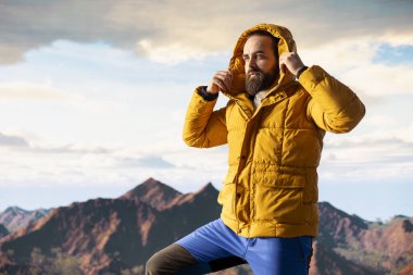 Yürüyüş yolcusu, tepedeki panoramik dağ manzarasına, sonsuz gökyüzüne ve kayalık tepelere hayranlık duymak için ara verir. Zihinsel berraklık için nefes kesici bir zemin oluşturur. Dışarıdaki maceracı..