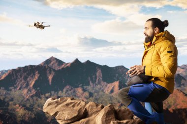 Modern gezgin, içerik yaratır ve dronuyla vadiyi filme çeker yüksek rakımlı bir dağ sırasının tepesine tırmanır. Manzaranın tadını çıkaran yürüyüşçü, uzaktan kumanda..