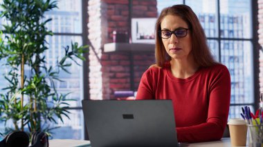 Olgun kişi iş programını denetliyor ve masasında planlama faaliyetleri yapıyor, dijital aletlerle zaman yönetimi üzerinde çalışıyor. Serbest çalışan bir kadın bilgisayar ve çoklu görevleri kullanıyor. Kamera A.