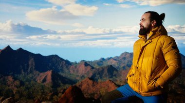 Yürüyüşçü, vahşi doğada yürümenin zorluğunu kucaklıyor, panoramik dağ manzarasının tadını çıkararak, gücün ve açık hava macerasının ödüllerini anımsatıyor. Maceraperest. Kamera A.