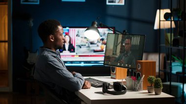Siyah işçi lideriyle video konferans görüşmesi yoluyla görüşüyor, ev ofisinden görevlerini ve görüşlerini paylaşıyor. Genç yetişkin, patronla internet sohbetine katılıyor. Kamera B.