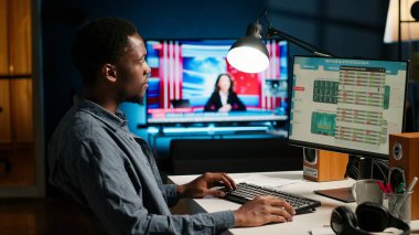 Afrika kökenli Amerikalı yatırım uzmanı evde mali istatistikleri analiz ederek büyüme için küresel bir yatırım çözümü geliştiriyor. Ekonomi danışmanı gelir beyannamesini inceliyor. Kamera A.